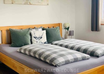 Chalet Lindenbuch: Das Doppelbett in Schlafzimmer 2 mit Zierkissen