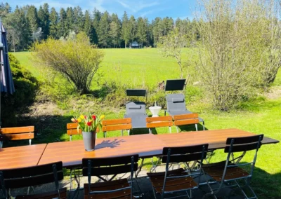 Großer Gartentisch mit Stühlen und zwei Liegestühlen im Garten des Ferienhauses Brestenberg.