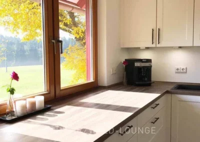 Helle Landhausküche im Ferienhaus Brestenberg mit Blick auf die umliegenden Wiesen und Wälder.