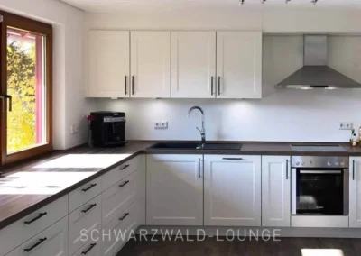 Helle Landhausküche im Ferienhaus Brestenberg mit großen Fenstern, viel Arbeitsfläche und moderner Ausstattung.