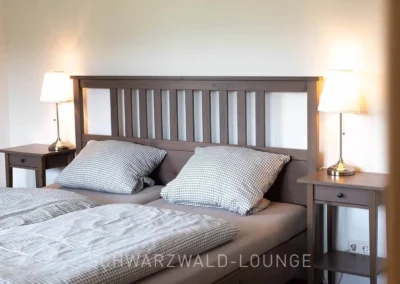 Gemütliches Schlafzimmer im Ferienhaus Brestenberg mit Holzrahmenbett und warmem Licht.