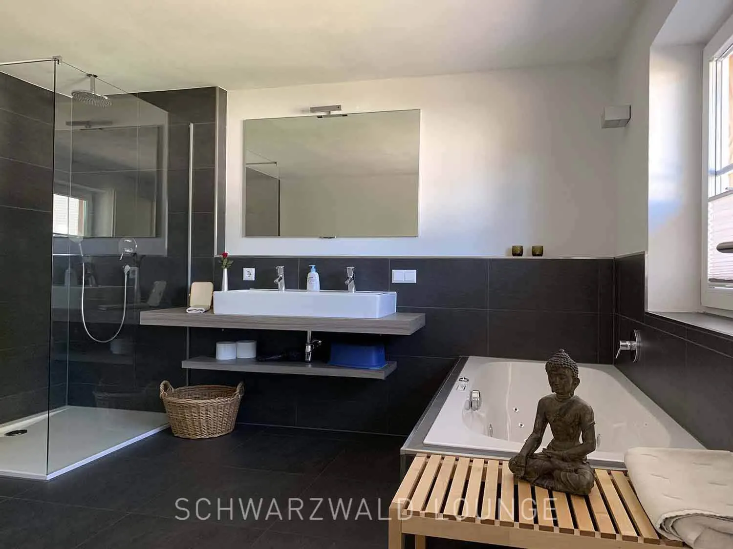 Chalet Schwarzwald – Modernes Bad mit Whirlpool | Lindenbuch Helles Badezimmer mit Whirlpool, großem Spiegel und moderner Ausstattung im Chalet Schwarzwald Lindenbuch.