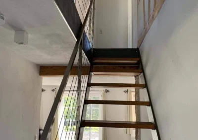 Offene Holztreppe mit Galerie und modernem Geländer im Chalet Schwarzwald Lindenbuch.