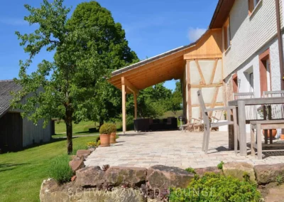 Seitliche Außenansicht vom Chalet Schwarzwald mit großer Sonnenterrasse und naturbelassenem Garten.