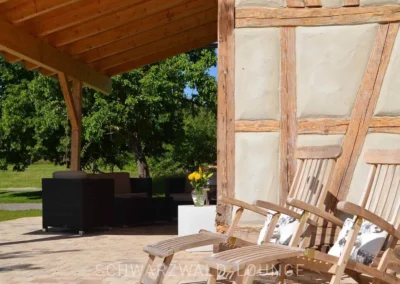Holz-Liegestühle an der Fachwerk-Terrasse des Chalet Schwarzwald Lindenbuch mit Blick ins Grüne.