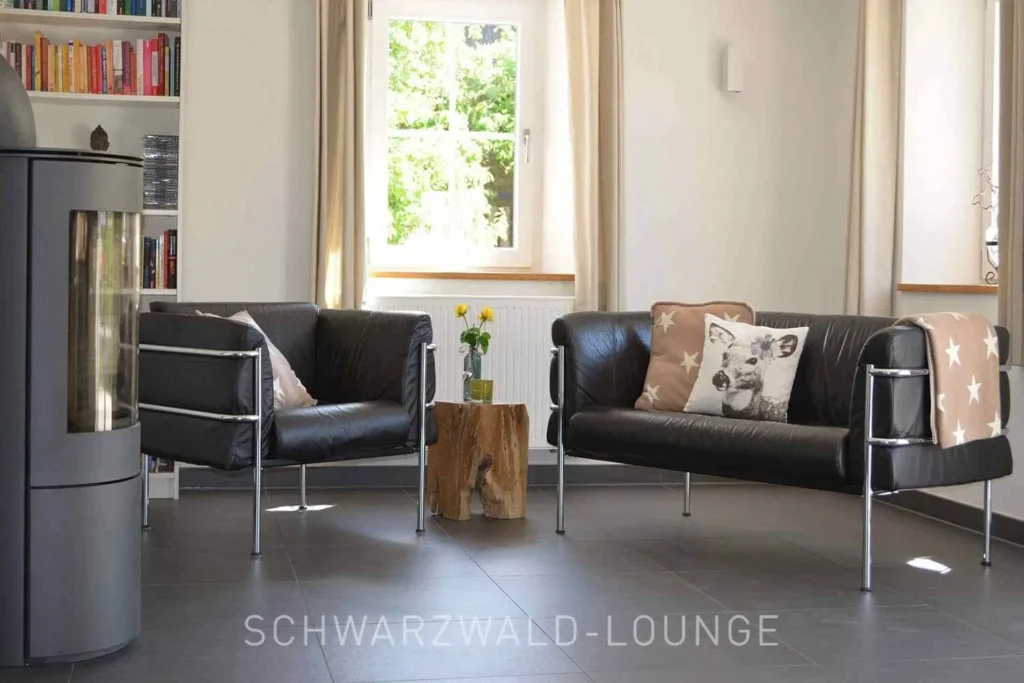 Gemütliche Kamin-Leseecke mit Sesseln im Wohnzimmer des Chalet Schwarzwald Ferienhauses Lindenbuch