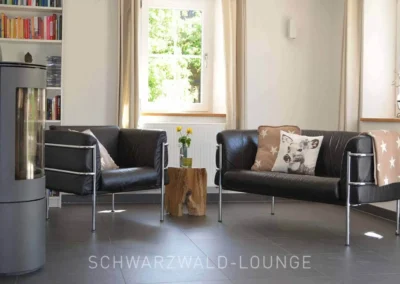Gemütliche Kamin-Leseecke mit Sesseln im Wohnzimmer des Chalet Schwarzwald Ferienhauses Lindenbuch