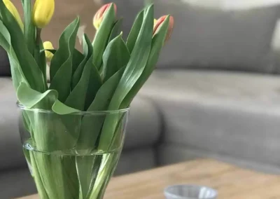 Tulpenstrauß auf massivem Holztisch im Wohnzimmer des Chalet Schwarzwald im Ferienhaus Lindenbuch.