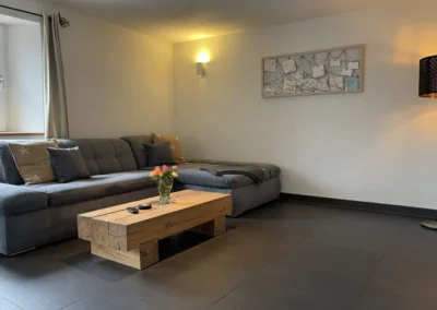 Große graue Sofaecke im hellen Wohnzimmer des Chalet Schwarzwald Ferienhaus Lindenbuch.