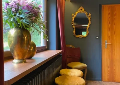 Billardzimmer mit dekorativer Vase, goldenen Samthockern und Fensterblick in der Gruppenunterkunft Schwarzwald.