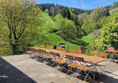 Große Terrasse mit langer Holztafel und Blick ins grüne Tal des Schwarzwalds.