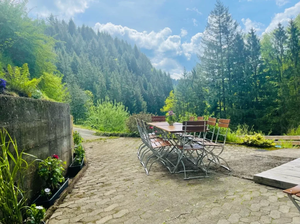 Große Terrasse mit Sitzgruppe und Blick in den Wald bei der Gruppenunterkunft im Schwarzwald.