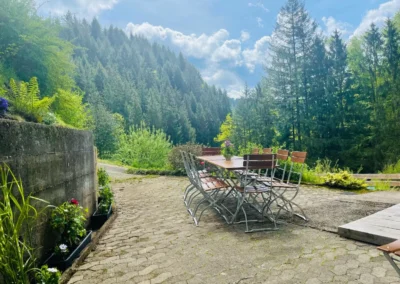 Große Terrasse mit Sitzgruppe und Blick in den Wald bei der Gruppenunterkunft im Schwarzwald.