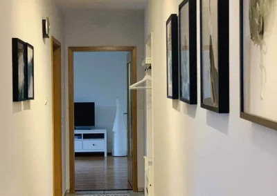 Helle Diele der Ferienwohnung Kinzigtal mit Wandbildern, Garderobe und Blick ins Wohnzimmer