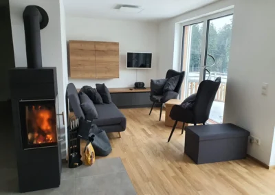 Wohnzimmer mit Kamin, Sofa und Ohrensesseln in der Ferienwohnung Ostweg im Schwarzwald