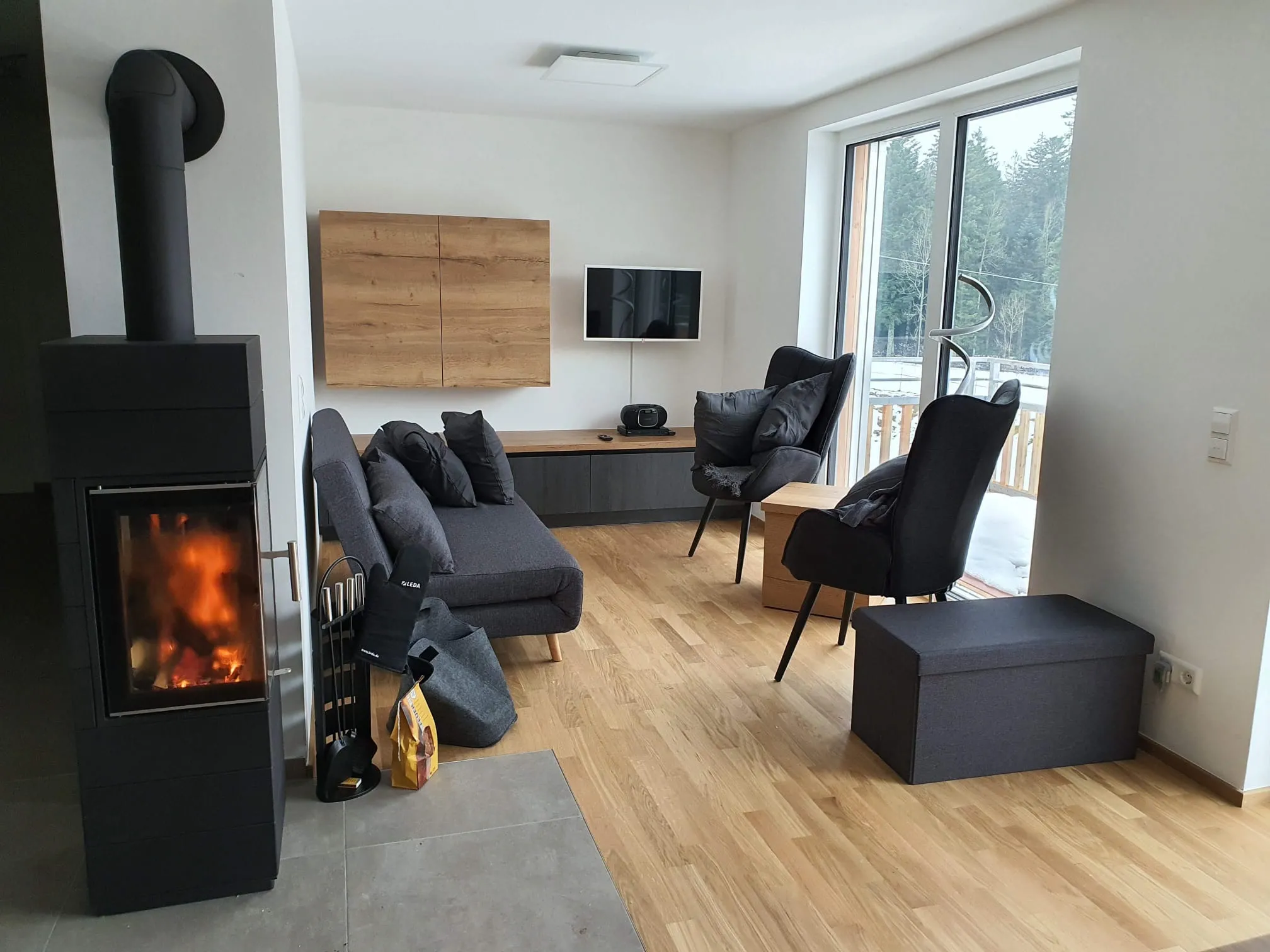Wohnzimmer mit Kamin, Sofa und Ohrensesseln in der Ferienwohnung Ostweg im Schwarzwald