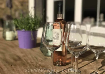 Weingläser und Flasche Rosé auf dem Terrassentisch des Schwarzwald Chalet Lohmühle.