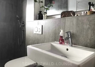 Elegante Bad-Suite im Schwarzwald Chalet Lohmühle mit Dusche und Waschbecken.