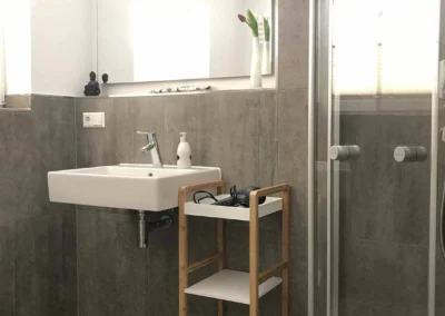 Helles Bad im Schwarzwald Chalet Lohmühle mit Spiegel, Waschbecken und moderner Ausstattung.