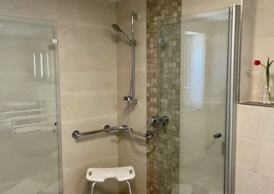 Barrierefreies Badezimmer der Ferienwohnung Westweg mit ebenerdiger Dusche und Duschhocker.