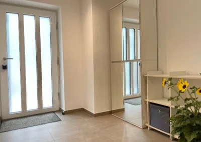 Großer Eingangsbereich der Ferienwohnung Westweg mit Spiegel, Garderobe und viel Stauraum.