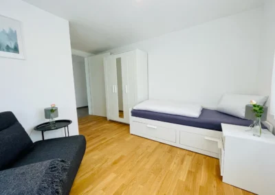 Zweites Schlafzimmer der Ferienwohnung Westweg mit Schlafcouch, Einzelbett und modernem Kleiderschrank.