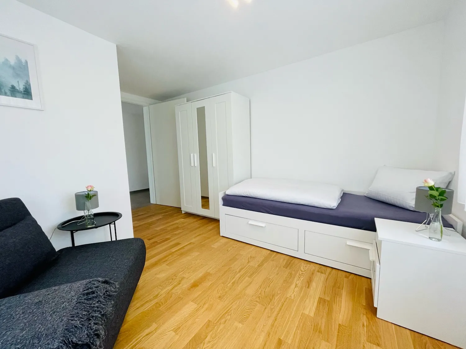Zweites Schlafzimmer der Ferienwohnung Westweg mit Schlafcouch, Einzelbett und modernem Kleiderschrank.
