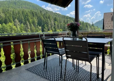 Balkon der Ferienwohnung Bergsee mit Esstisch und Aussicht auf Schwarzwaldberge.