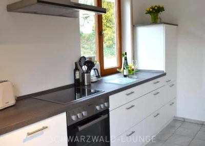 Moderne große Küche der Ferienwohnung Bergsee im Schwarzwald mit Fenster, Arbeitsfläche und Ausstattung.