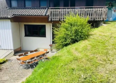 Sonniger Außenbereich der Gruppenunterkunft Schwarzwald mit großer Sitzgruppe für viele Personen.