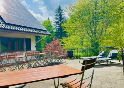 Große Sonnenterrasse der Gruppenunterkunft Schwarzwald mit Liegen und langer Sitztafel.