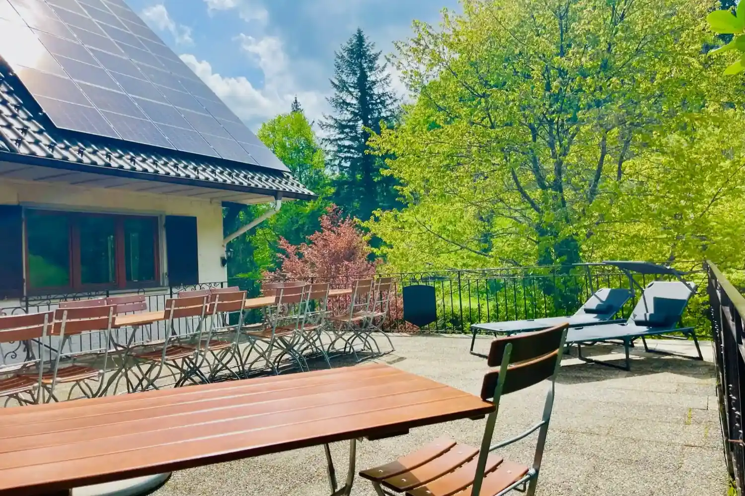 Große Sonnenterrasse der Gruppenunterkunft Schwarzwald mit Liegen und langer Sitztafel.