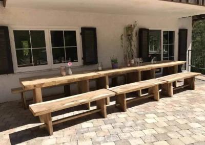 Überdachte Terrasse im Schwarzwald Chalet Lohmühle mit langen Massivholztischen und Holzbänken.
