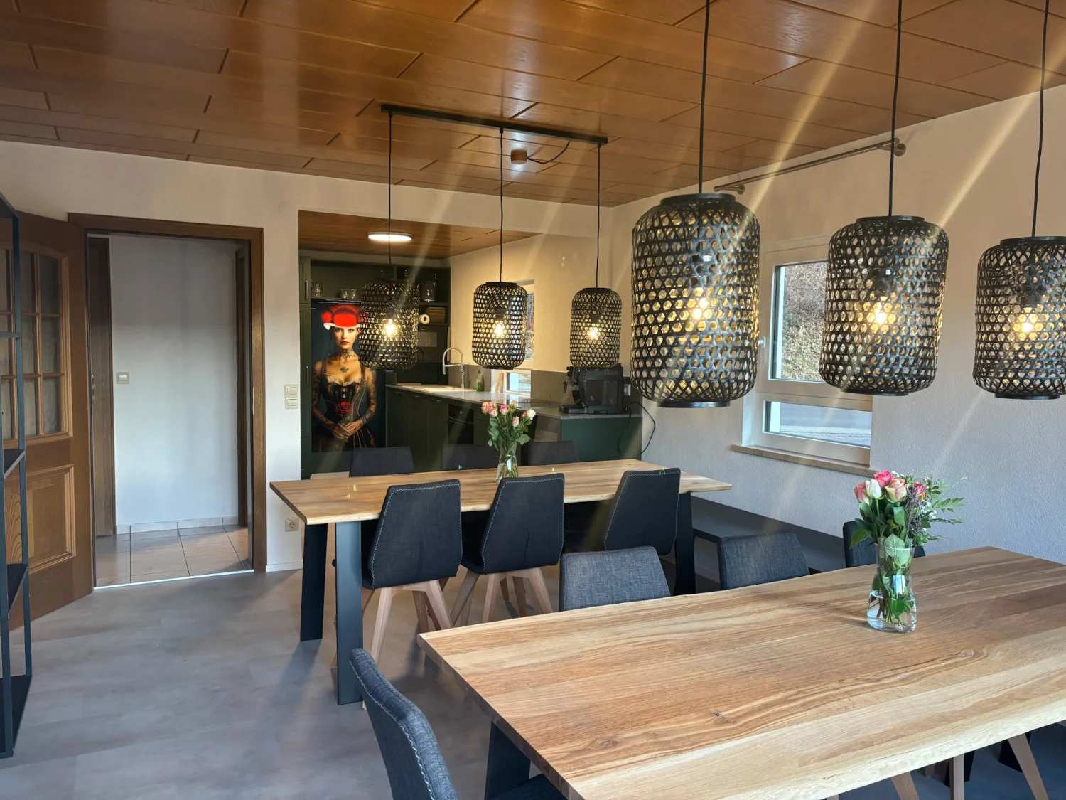 Tanne und Tal Relax – Essbereich mit Holztischen & Pendelleuchten | Schwarzwald-Lounge Großzügiger Essbereich im Ferienhaus Tanne und Tal Relax mit Holztischen, modernen Pendelleuchten und Blick zur Küche von Schwarzwald-Lounge