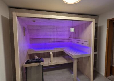 Moderne private Sauna im Ferienhaus Tanne und Tal Relax mit LED-Ambientebeleuchtung und Glasfront.