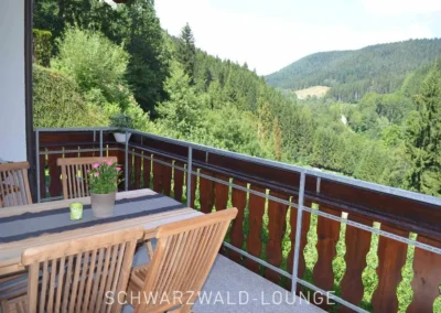 Balkon mit Holztisch und Blick ins Tal bei der Ferienwohnung Waldwiese
