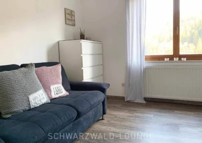 Helles, modernes Schlafzimmer mit großem Fenster und gemütlicher Einrichtung.