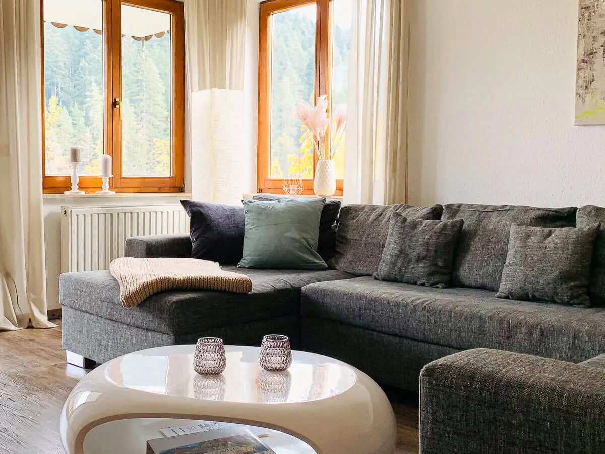 Detailaufnahme des Sofas im Wohnzimmer der Ferienwohnung Waldwiese mit gemütlicher Dekoration.