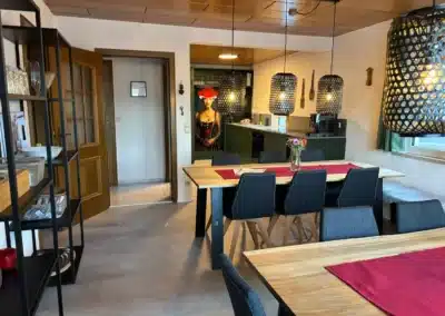 Essbereich mit Blick auf die grüne Küche und Pendelleuchten im Ferienhaus Tanne und Tal Relax