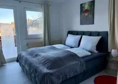 Helles Schlafzimmer mit komfortablem Doppelbett, Fensterblick und ruhiger Atmosphäre im Ferienhaus Tanne und Tal Relax im Schwarzwald.