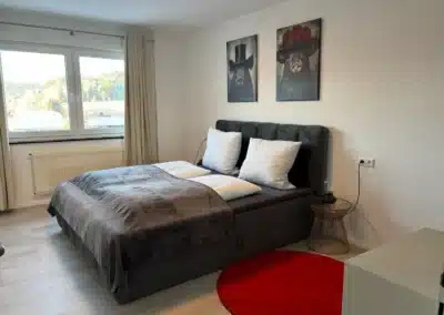 Helles Schlafzimmer mit Doppelbett und Fensterblick im Ferienhaus Tanne und Tal Relax im Schwarzwald.