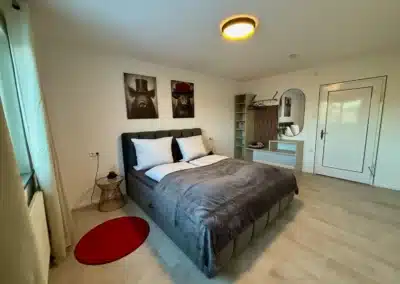 Weitwinkelansicht eines modernen Schlafzimmers mit Doppelbett im Ferienhaus Tanne und Tal Relax im Schwarzwald.