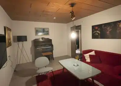 Gemütlicher TV-Raum mit Klavier und Sofa im Ferienhaus Tanne und Tal Relax der Schwarzwald-Lounge