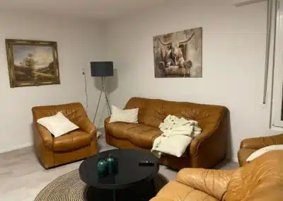 Wohnzimmer mit Ledersofas und Couchtisch im Ferienhaus Tanne und Tal Relax der Schwarzwald-Lounge