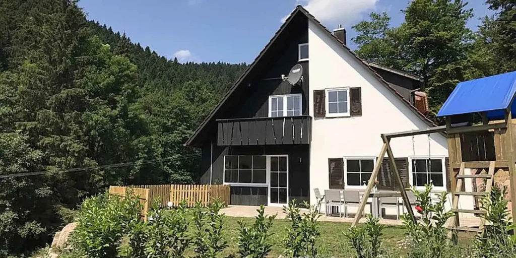 Außenansicht des Schwarzwald Chalet Lohmühle mit Terrasse, Garten und Spielturm.