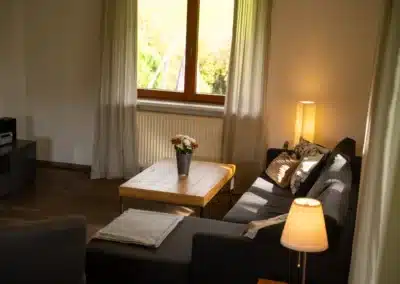 Helles Wohnzimmer mit großen Fenstern im Haus Brestenberg – Schwarzwald-Lounge