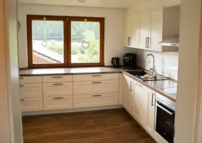 Helle Küche im Haus Brestenberg mit großem Fenster – Schwarzwald-Lounge