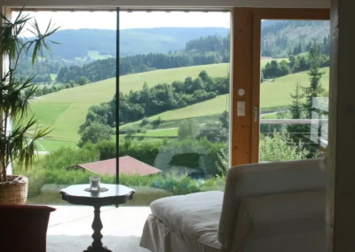 Ferienhaus Baiersbronn – Wohnzimmer mit großer Fensterfront und Panoramablick über den Schwarzwald