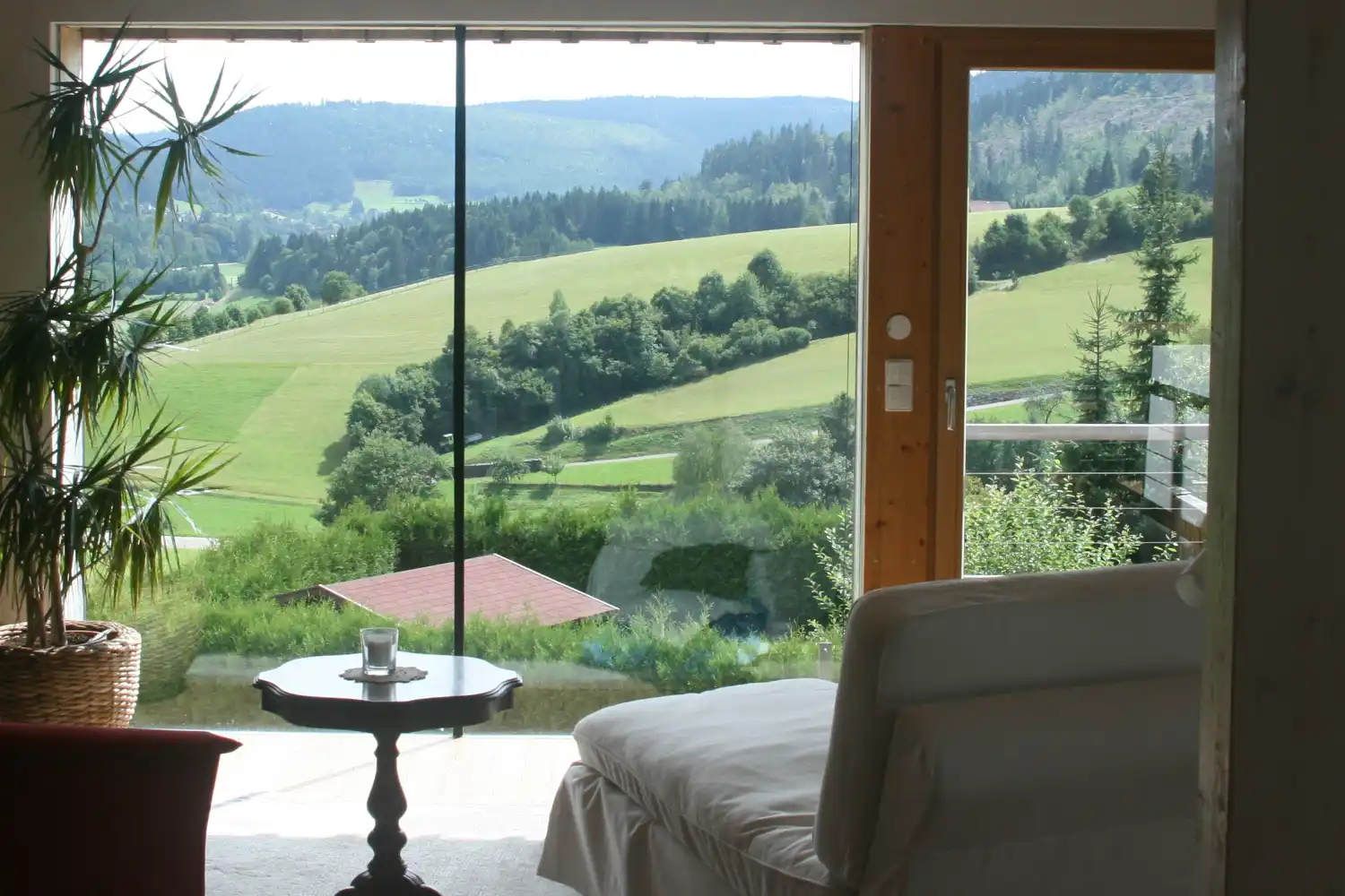Ferienhaus Baiersbronn – Wohnzimmer mit großer Fensterfront und Panoramablick über den Schwarzwald