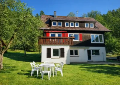 Hausfront von Tanne und Tal Relax im Sommer mit großer Rasenfläche, Sitzgruppe im Garten und sonniger Lage im Schwarzwald